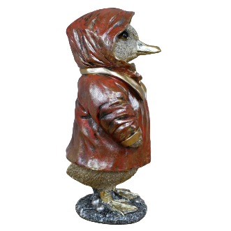Statue of a duck wearing a red coat and scarf on a wooden surface with a stone wall background.